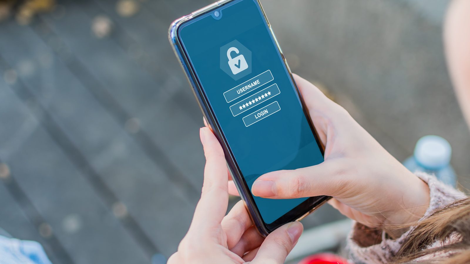 A woman outdoors holds a phone showing a login screen with a padlock, username and password fields.